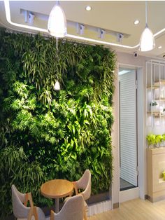 a living room with a green wall in the center and two chairs at a table