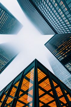 looking up at skyscrapers in the city from ground level, with bright lights shining on them