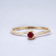 a gold ring with a red stone in the middle and an inscription on it that says avr creations