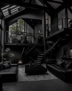 a living room filled with black furniture and lots of windows