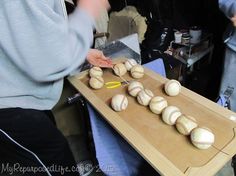 a person cutting up some baseballs on a table