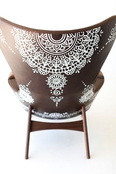 a brown and white bowl sitting on top of a wooden stand