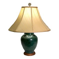 a green lamp with a beige shade on it