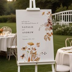 an easel with a wedding sign on it in front of some tables and chairs