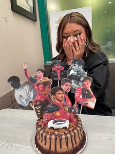 a woman covering her face in front of a cake with photos of people on it