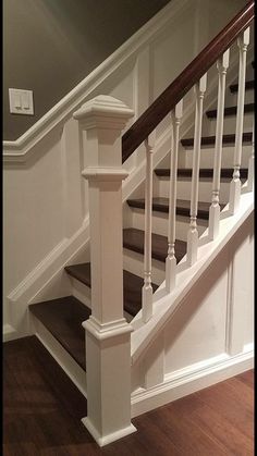 a white staircase with wooden handrails in a house