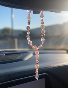 a car dashboard with some beads hanging from it