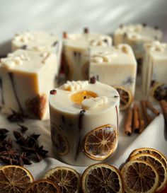 orange slices and cinnamons are arranged on a table with soap bars, cinnamon sticks, and star anise