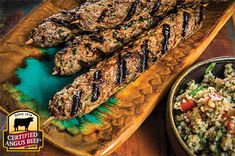 grilled steaks and rice on a wooden platter