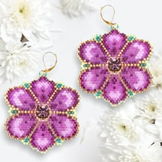 two pairs of purple and green beaded flower earrings on white flowers with gold earwires