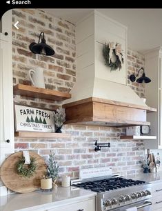 a kitchen with brick wall and white cabinets, stove top oven and wooden shelfs