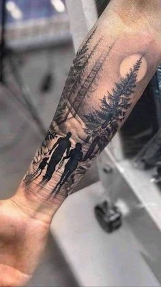 a person with a tattoo on their arm that has two people walking in the woods