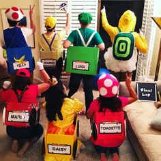 group of people dressed up as mario and luigi in front of a living room door