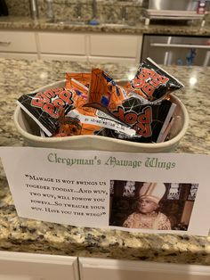 a bowl filled with candy sitting on top of a counter next to a sign that says,