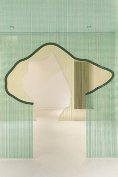 an art installation with green and white stripes on the wall, in front of a mirror