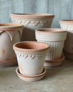 several clay pots and saucers sitting on a table