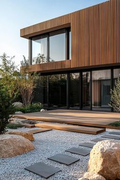 an outdoor area with stepping stones, gravel and wooden slatted building in the background