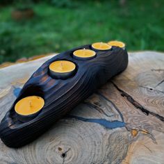 a wooden table topped with candles and a piece of wood on top of the table