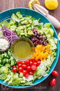 a salad with olives, tomatoes, lettuce and other vegetables on it