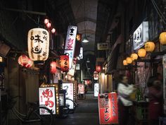 an alley way with many signs and lights on the buildings at night in asia stock photo