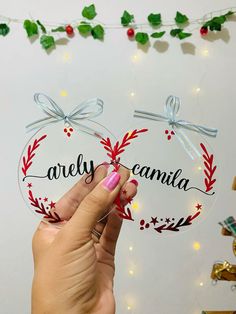 a person holding up a glass ornament with the words, arely camila