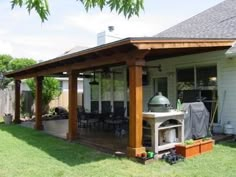 a covered patio with an outdoor kitchen and grill