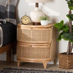 a wicker dresser with a clock and potted plant next to it on a rug