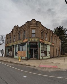 an old run down building sitting on the side of a road