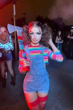 a woman in overalls and colorful makeup