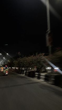 a person riding a motorcycle down a street at night