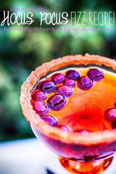 a close up of a drink in a wine glass with grapes on the rims