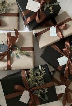 several wrapped presents with brown ribbons and flowers on them are sitting on the floor next to each other