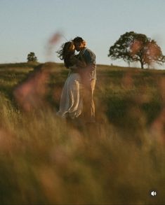 a man and woman are standing in the grass