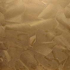 an abstract gold background with wavy lines and curves in the center, as if it were painted on paper