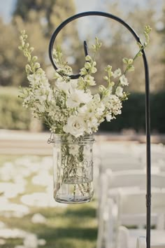 a mason jar filled with white flowers sitting on top of a table