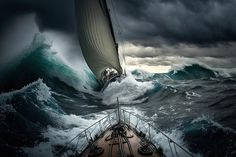 a boat in the middle of a large ocean with storm clouds above it and an overcast sky