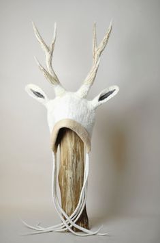 a white deer head with antlers on top of a wooden pole and rope wrapped around it