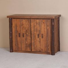 a wooden cabinet sitting on top of a carpeted floor next to a white wall