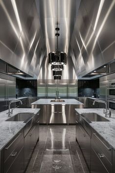 a large kitchen with stainless steel appliances and marble counter tops