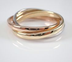 three different colored gold rings sitting on top of each other