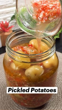 pickled potatoes in a glass jar with water pouring from the top into the jar