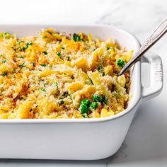 a casserole dish with peas, cheese and parmesan on the side