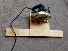 a corded sanding machine sitting on top of a piece of plywood plank