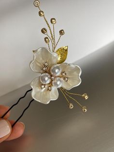 This handmade floral gold hairpin - features a delicate white pearl flower crafted with gold-colored wire, adorned with small gold beads, and leaves, and secured with a bobby pin. 🌼Perfect for a classy, messy, or textured wedding updo. 🌼This versatile bridal hairpiece adds a touch of sophistication to any wedding gown design.  With a length of 8cm (3.1 inches) It is ready to ship. If you liked this hair piece, you could like also those hair pins, take a look: https://visageroomdesigns.etsy.com/listing/1657905358 https://visageroomdesigns.etsy.com/listing/1670786761 Bridal Side Hair, Side Hair Clip, Elegant Gold Flower Brooches, Gold Flower-shaped Wedding Brooches, Glass Flower Hairpin, Elegant Flower-shaped Hair Accessories With Handmade Flowers, Gold Flower Hair Pin, Gold Hair Piece, Side Hair