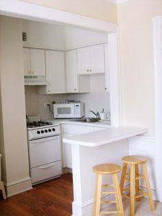 an empty kitchen with two stools in it