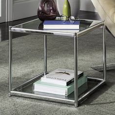 a glass and metal end table with books on top