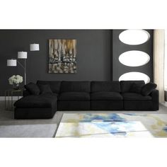 a black couch sitting in front of a gray wall