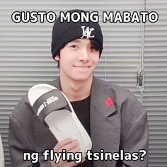 a man in a black beanie is holding a pair of shoes and has the caption, gusto mong mabato ng flying tsinelas?