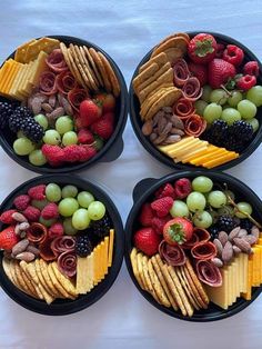 four black bowls filled with different types of food