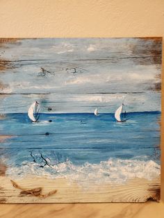 a painting of sailboats in the ocean on a wooden board with seagulls flying above